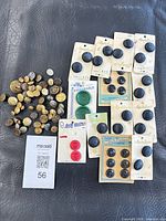 Full lot overview showing loose metal buttons and carded plastic buttons