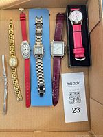All six watches arranged in box showing variety of straps and metal bracelets