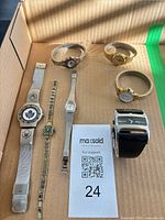 Seven watches laid out in tray showing overall assortment