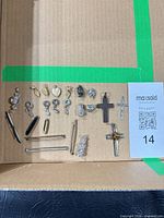 Overall layout of approximately 20 jewelry items including charms, crosses and tie bars