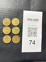 Obverse view of six brass tokens showing BRIDGE TOKEN text.