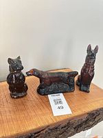 front view of three brown-amber glass dog bottles