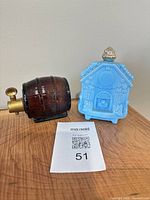 Brown glass barrel decanter and blue milk glass house perfume bottle together