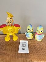Front view of waiter figure and two ceramic bird shakers