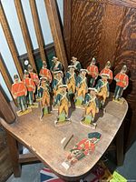 Group of 17 paper soldier standees on wooden chair
