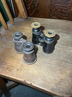 Two pairs antique binoculars on wooden chair