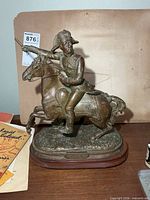 Full view of bronze-tone Wellington equestrian statue on wooden base