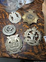 Group shot of all five cap badges on table