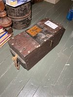 Overall view of solid wood military box showing rope handle, sliding lid, label and hardware