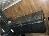 Overall view of closed black metal military trunk