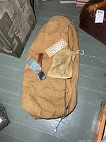 Top view of tan canvas duffle bag with small pouch on top