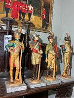 All four resin military figures on marble bases displayed together