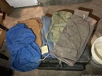 Blue, green and brown canvas duffle bags on surface