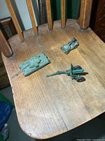 Group shot of tank, cannon and jeep on wooden chair seat