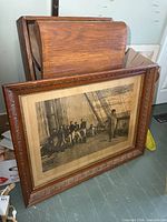 Full view of framed print leaning against wall