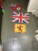 Overview of all three linen flags on floor showing relative sizes and wooden sticks
