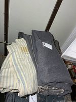 Stack of one solid grey wool blanket and two striped wool blankets on trunk