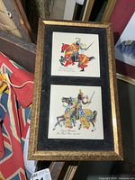 Front view of framed pair of ceramic tiles with knight illustrations