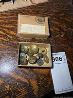 closed box and contents overview, showing mixed brass buttons