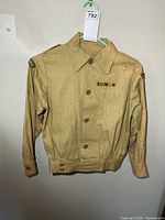 Full view of khaki military shirt hanging