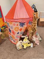 Full view of floral tent with giraffe and plush toys arranged in front