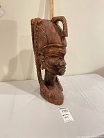 Front three-quarter view of entire wooden bust with ruler for scale