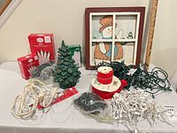 Full lot overview showing ceramic tree, boxed and loose lights, snowman sign, cords, ribbon