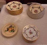 Stacks of dinner and side plates showing floral gilt dinner plates beside storage container