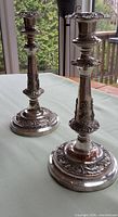 Both ornate silver-plated candlesticks front view