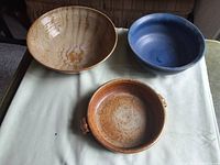 Top view of three pottery bowls laid out on fabric surface