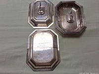 Three of the silver-plated dishes showing lids, bases and engraved presentation inscription.