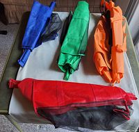 Five folded reusable bags in blue, green, orange, red with mesh sections