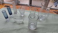 Eight assorted glass vases on table