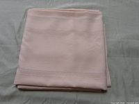 folded cream tablecloth showing overall colour and stitching