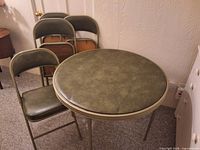 round green card table with four matching folding chairs