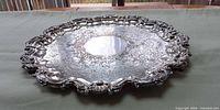 Top view of ornate silver-plated round tray showing full design