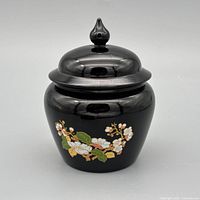 Full view of black glass jar with lid and floral design