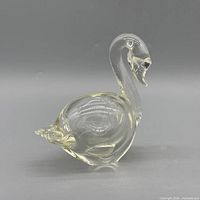 Left side view of clear yellow-tinted glass swan