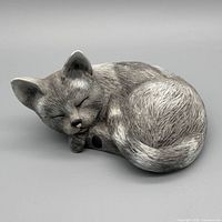 Full view of gray resin sleeping cat figurine