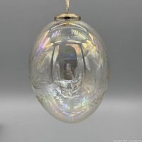 Iridescent glass globe with etched leaves, metal cap and ribbon hanger