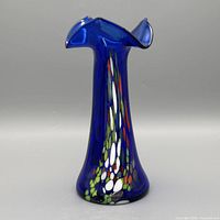 Full view of cobalt blue art glass vase showing multicolor murrine pattern and asymmetric rim
