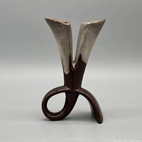 Front view showing twin flared spouts, looped base, brown and beige glazing