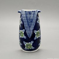 Front view of navy blue porcelain wall pocket vase with floral pattern