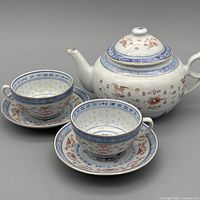 Full view of teapot, two cups and two saucers