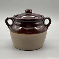 Front view of two-tone stoneware bean pot with lid and handles
