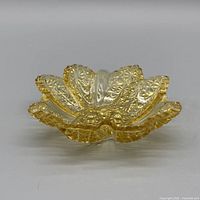 Front profile of amber pressed glass ruffled candy dish