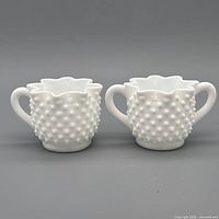Front view of creamer and sugar bowl showing hobnail pattern and ruffled rims