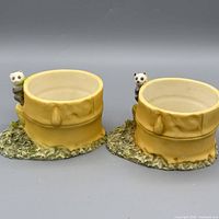 Pair of yellow bamboo-style ceramic planters with panda figures