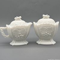 Front view of creamer and sugar bowl showing grape & cherry relief and pedestal bases