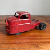 Left side view of red pressed steel truck cab